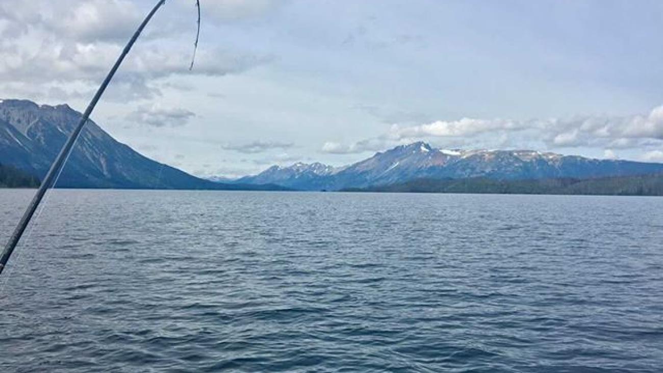 Majestic snow-covered mountains reflected on a perfectly still alpine lake.